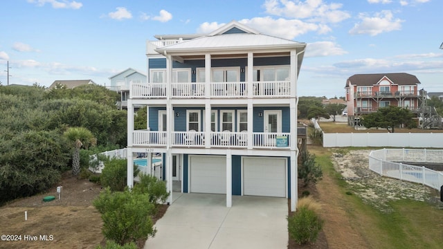 raised beach house with a garage and a balcony