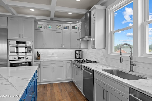 kitchen with decorative backsplash, light stone countertops, sink, and wall chimney exhaust hood