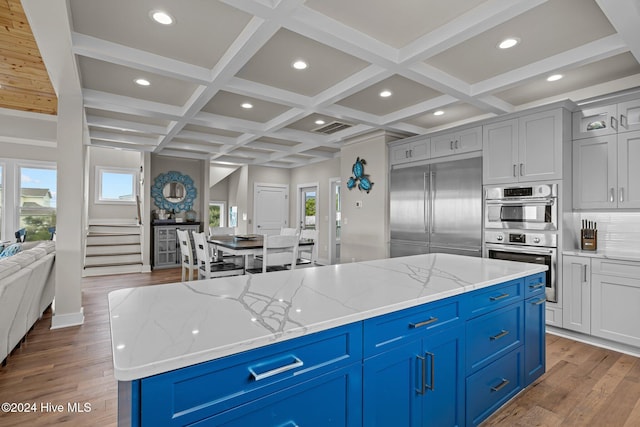 kitchen featuring stainless steel appliances, light stone countertops, and light hardwood / wood-style flooring