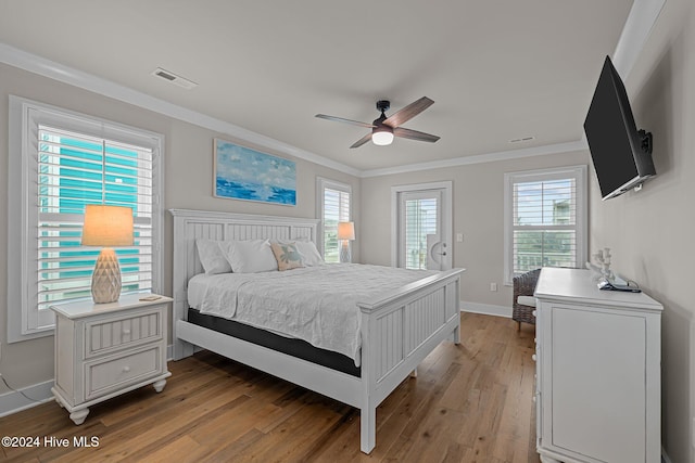 bedroom with ornamental molding, light hardwood / wood-style floors, multiple windows, and ceiling fan