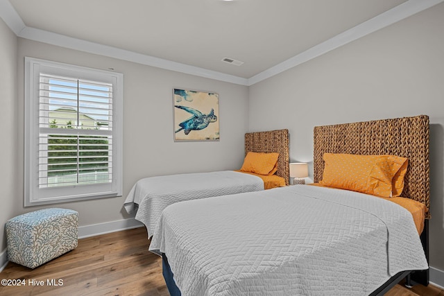 bedroom with hardwood / wood-style floors and ornamental molding