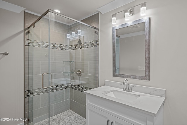 bathroom featuring vanity, an enclosed shower, and crown molding