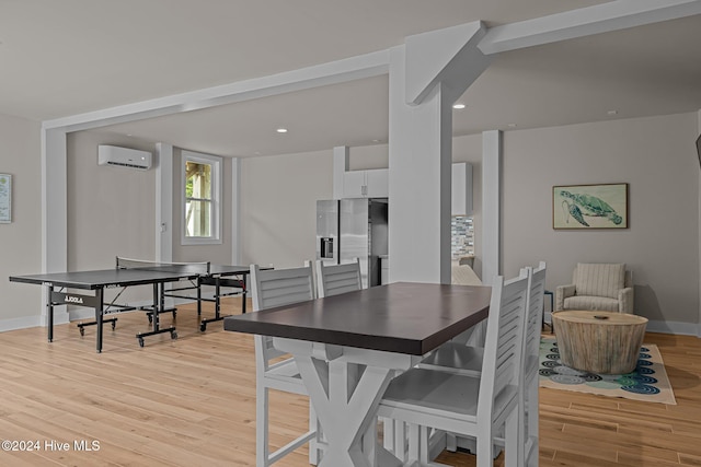 dining space featuring a wall mounted AC and light hardwood / wood-style flooring