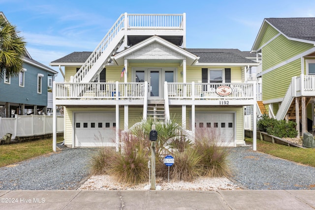 coastal inspired home with a garage and a porch