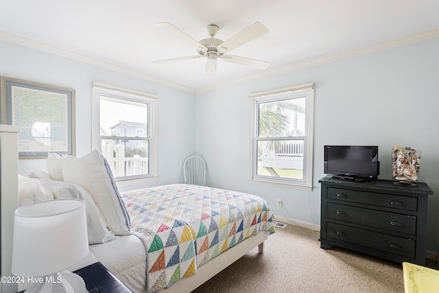 carpeted bedroom with ceiling fan and ornamental molding