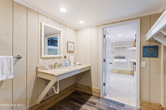 bathroom featuring hardwood / wood-style flooring, sink, and crown molding