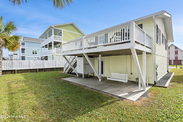 back of house with a lawn and a deck