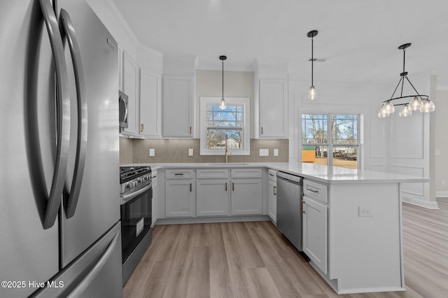 kitchen featuring white cabinets, kitchen peninsula, and appliances with stainless steel finishes