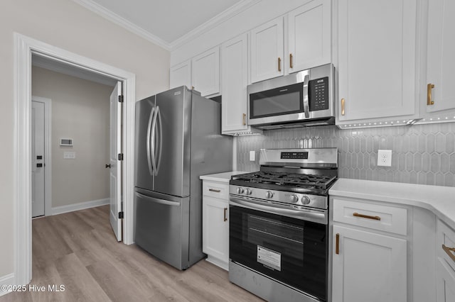 kitchen with stainless steel appliances, backsplash, crown molding, white cabinets, and light wood-type flooring