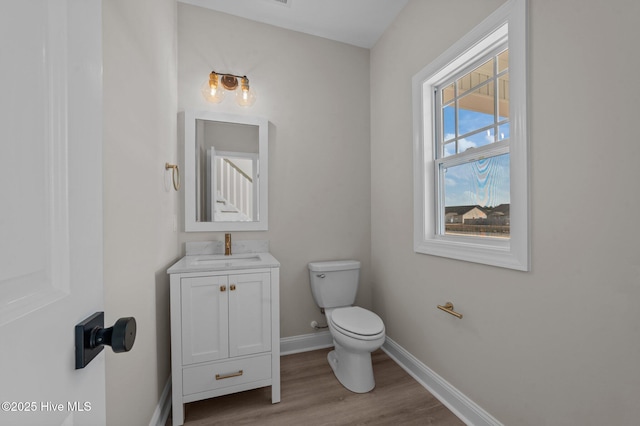 bathroom featuring vanity, wood-type flooring, and toilet