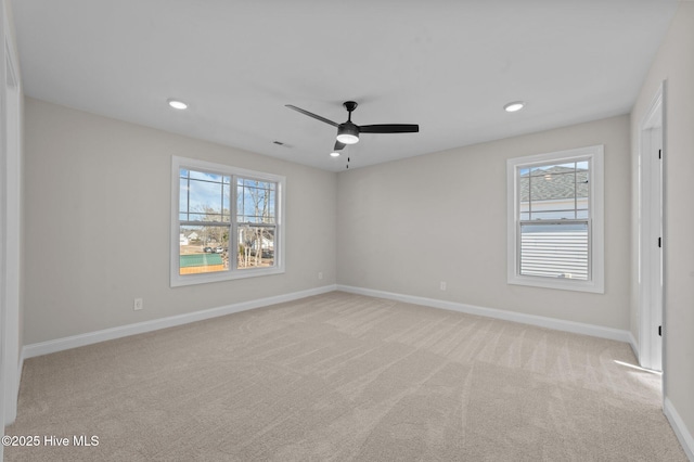 spare room featuring ceiling fan and light carpet