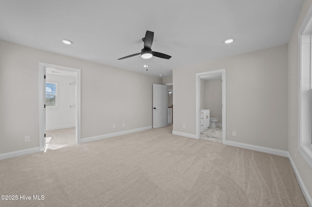 unfurnished bedroom featuring ensuite bathroom, ceiling fan, and light colored carpet