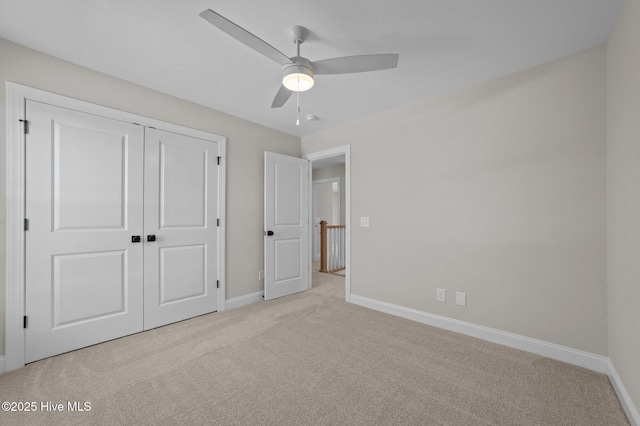 unfurnished bedroom featuring ceiling fan, a closet, and light carpet