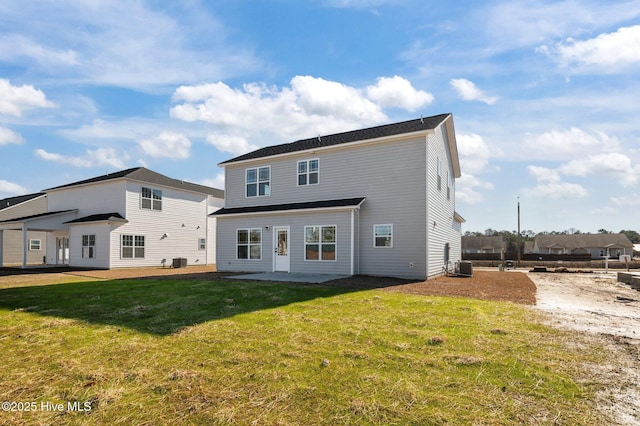 rear view of property with cooling unit, a yard, and a patio