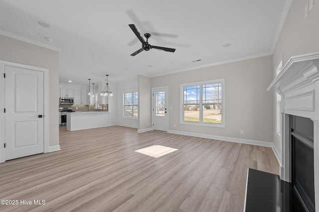 unfurnished living room featuring ceiling fan, light hardwood / wood-style floors, and ornamental molding