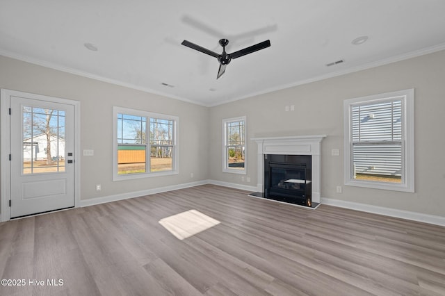 unfurnished living room featuring light hardwood / wood-style flooring, plenty of natural light, and ornamental molding