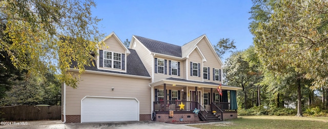 view of front of property featuring a garage, covered porch, and a front lawn