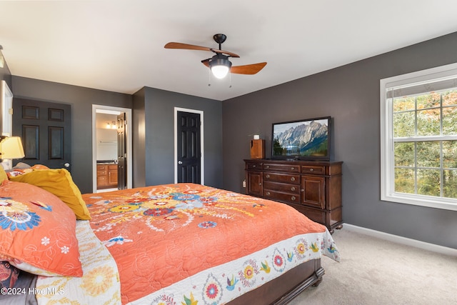 carpeted bedroom with ceiling fan and ensuite bathroom