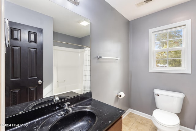 bathroom featuring tile patterned flooring, curtained shower, vanity, and toilet