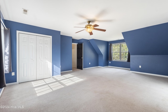 additional living space with ceiling fan, lofted ceiling, and light colored carpet