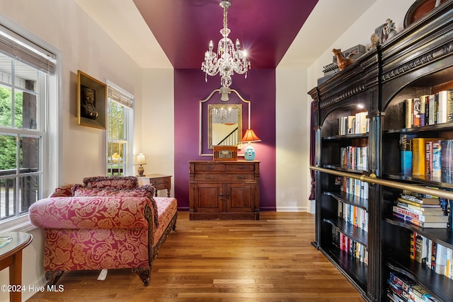 living area featuring a chandelier, hardwood / wood-style flooring, and plenty of natural light