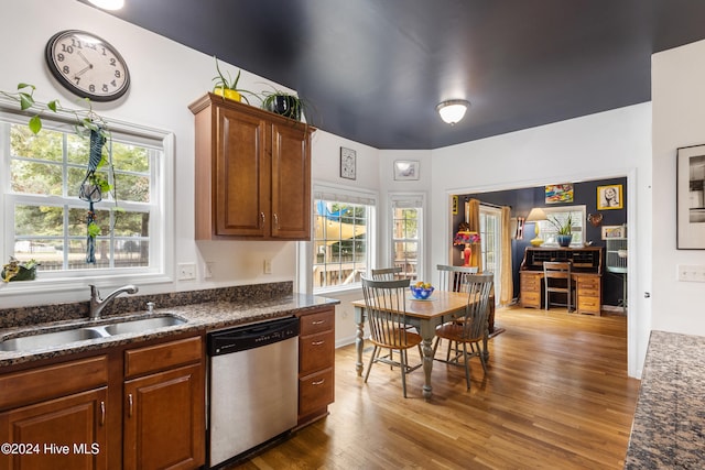 kitchen with stainless steel dishwasher, dark stone counters, sink, and dark hardwood / wood-style flooring