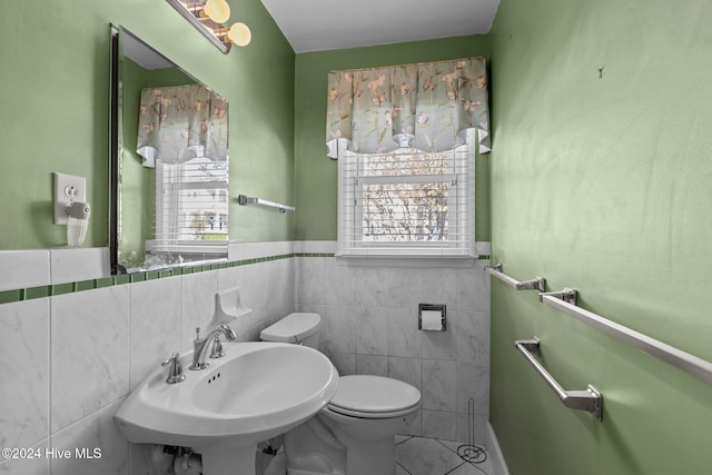 1701 Front St, Beaufort, NC 28516 - half bath featuring toilet, healthy amount of natural light, tile walls, wainscoting, and a sink