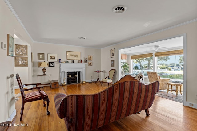 1701 Front St, Beaufort, NC 28516 - living area featuring wood finished floors, ornamental molding, a brick fireplace, a ceiling fan, and baseboards