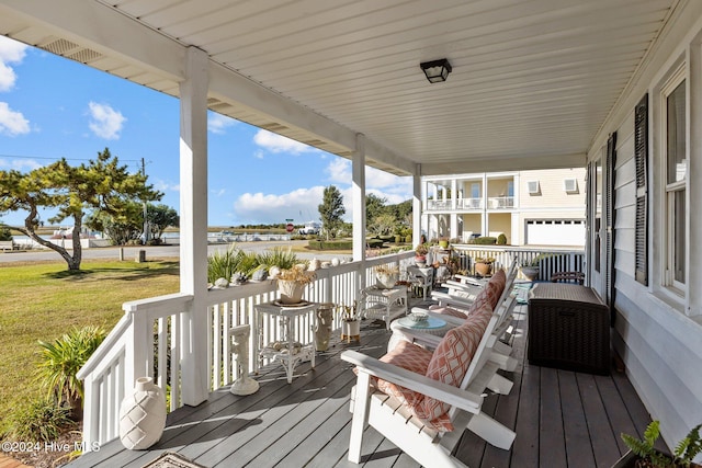 wooden deck with a lawn and covered porch