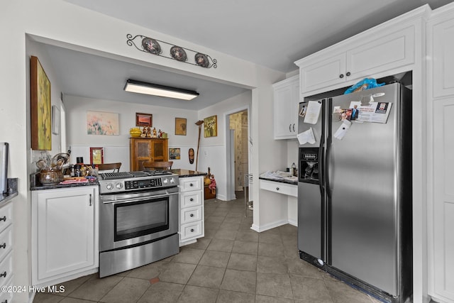 kitchen featuring dark tile patterned flooring, white cabinetry, and appliances with stainless steel finishes