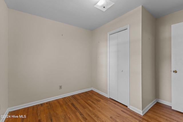 unfurnished bedroom with a closet and light hardwood / wood-style flooring