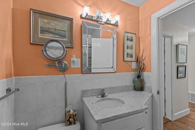 1701 Front St, Beaufort, NC 28516 - half bathroom featuring toilet, vanity, tile walls, and wood finished floors