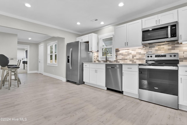 kitchen featuring sink, white cabinets, light wood-type flooring, and appliances with stainless steel finishes