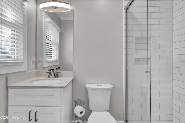 bathroom featuring walk in shower, vanity, toilet, and plenty of natural light