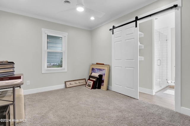 miscellaneous room with a barn door, ceiling fan, and carpet