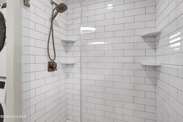 bathroom with washer / dryer and tiled shower