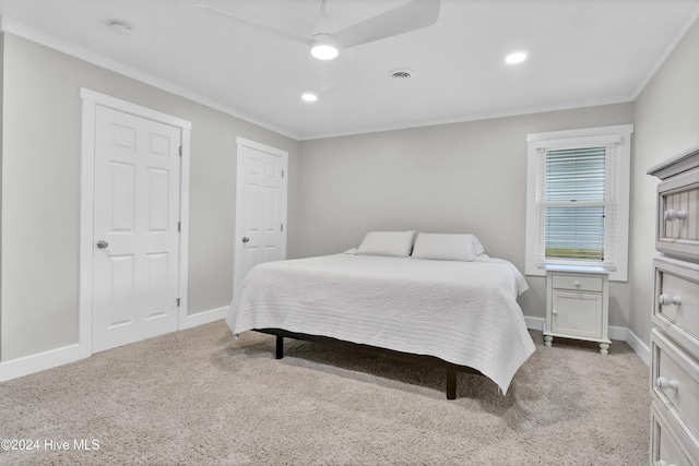 carpeted bedroom with ceiling fan and crown molding