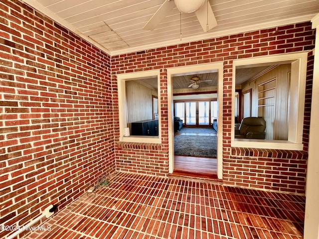 interior space featuring wooden ceiling, crown molding, and brick wall