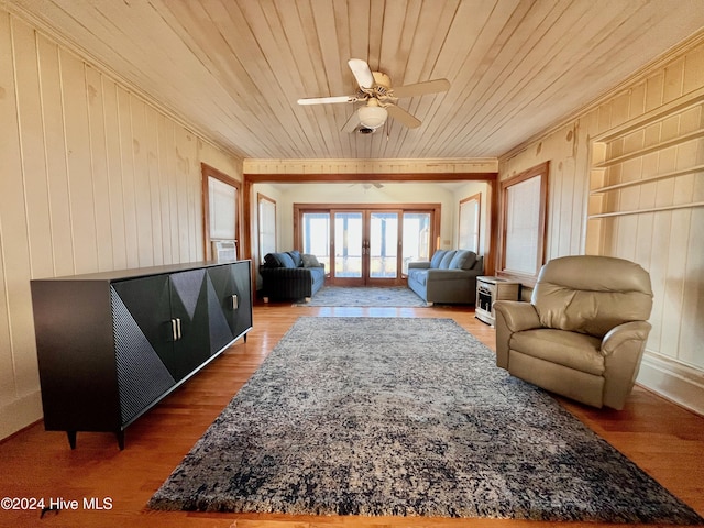 living area featuring wood walls, hardwood / wood-style floors, wood ceiling, and french doors