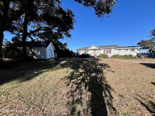 view of yard featuring a garage and an outdoor structure