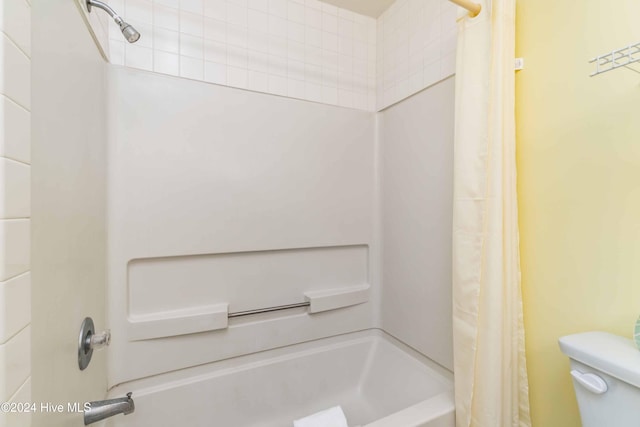 bathroom featuring shower / tub combo and toilet