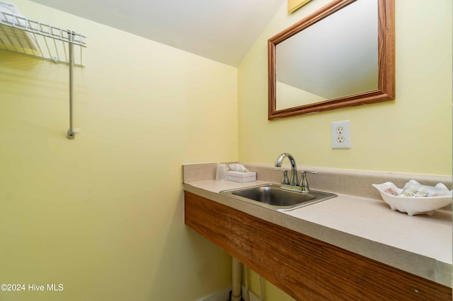 bathroom featuring lofted ceiling and sink