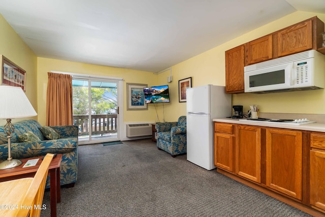 kitchen with a wall mounted air conditioner, white appliances, and dark colored carpet