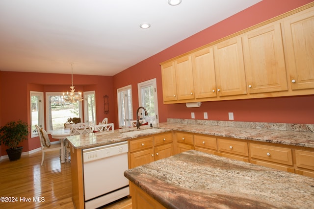 kitchen featuring white dishwasher, light wood-type flooring, kitchen peninsula, and a wealth of natural light