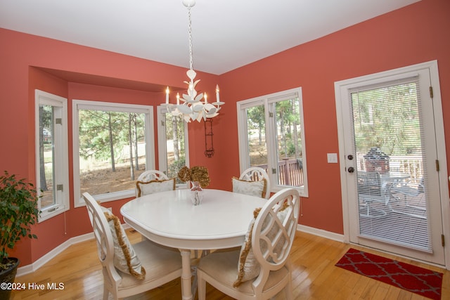 dining room with light wood-type flooring and a notable chandelier