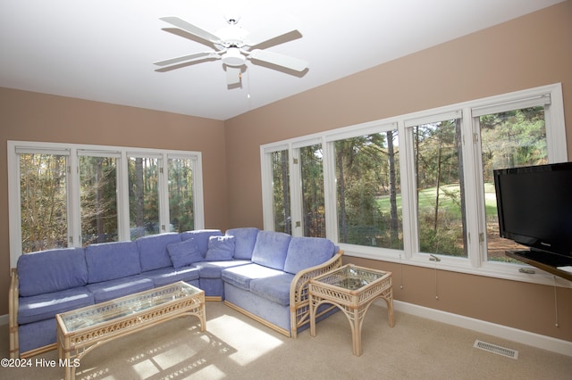 living room featuring ceiling fan, light colored carpet, and a healthy amount of sunlight