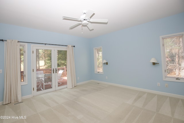 carpeted empty room featuring french doors and ceiling fan