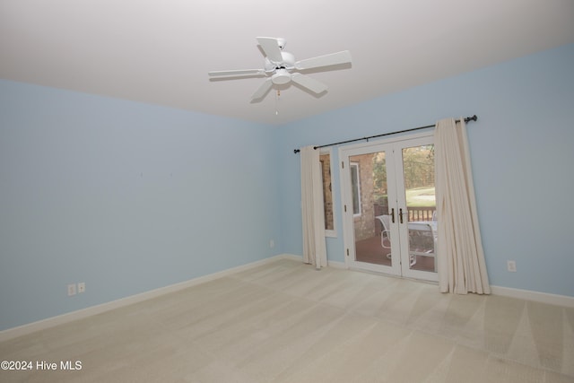 empty room featuring french doors, light colored carpet, and ceiling fan