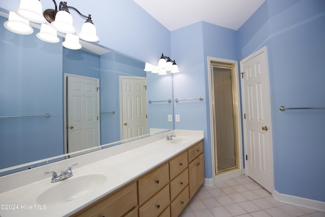 bathroom featuring tile patterned flooring, vanity, walk in shower, and a notable chandelier