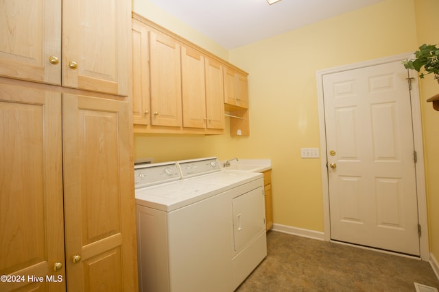 washroom with washing machine and clothes dryer, sink, cabinets, and dark carpet